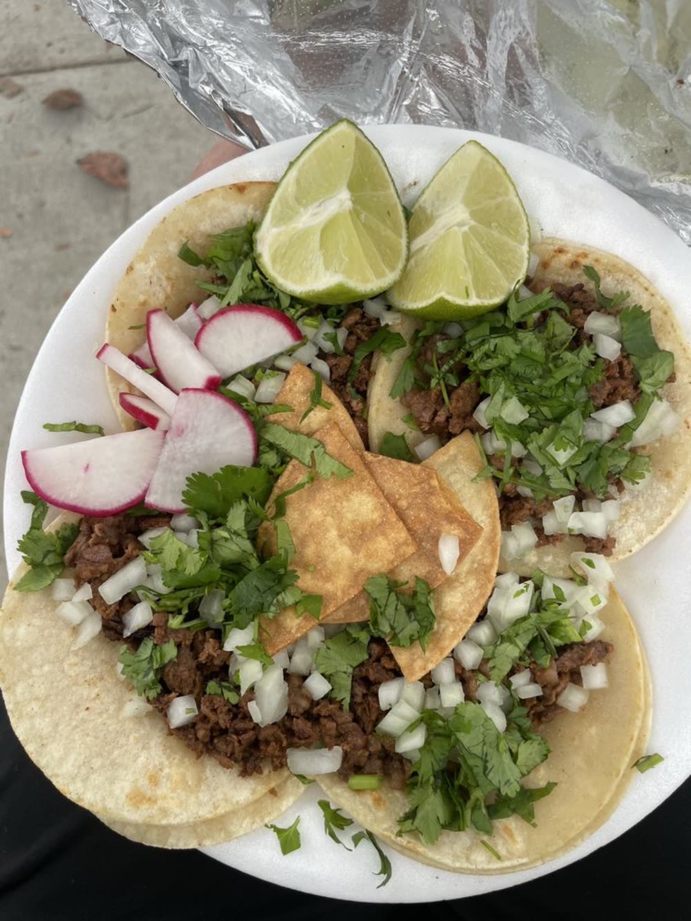 Plate of carne asada tacos with lime and radish